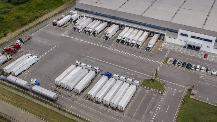 Vista aérea de pátio de galpão logístico com carretas nas docas